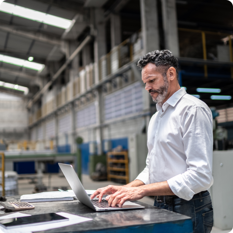 Responsable logistique pilotant son activité sur ordinateur en entrepôt